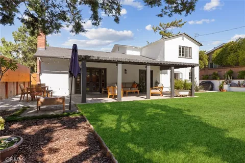a view of a house with backyard porch and sitting area
