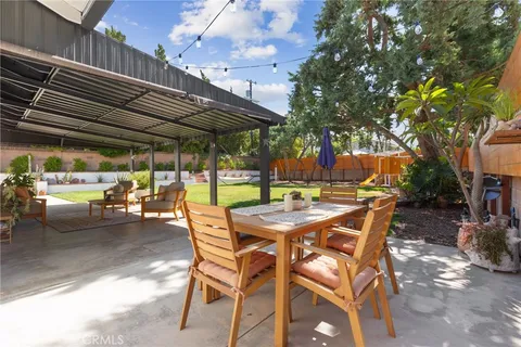 a view of patio with table and chairs and potted plants