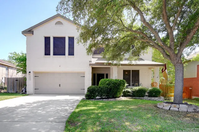 a view of a house with a yard and large trees
