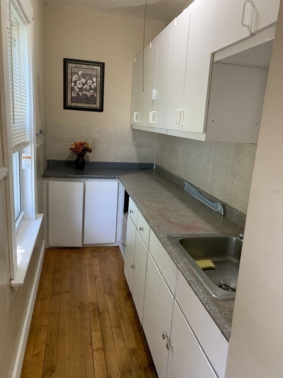 5 Rose Street Worcester, MA 01607 - Photo 12 of 30 a kitchen with granite countertop a sink and cabinets
