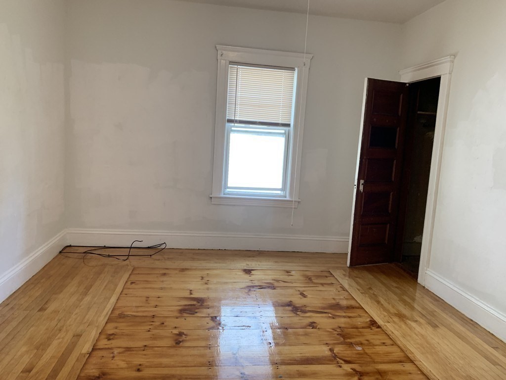 5 Rose Street Worcester, MA 01607 - Photo 17 of 30 an empty room with wooden floor and window