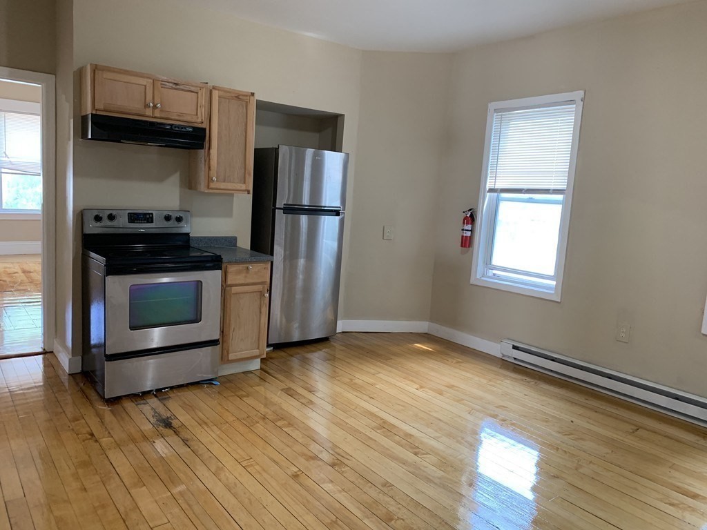 5 Rose Street Worcester, MA 01607 - Photo 10 of 30 a kitchen with granite countertop wooden floors and stainless steel appliances