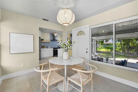 a dining room with furniture and large windows