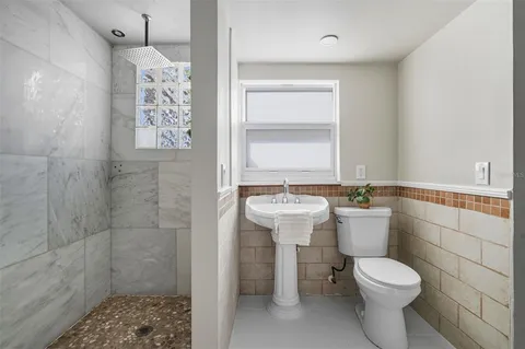 a bathroom with a toilet sink and shower