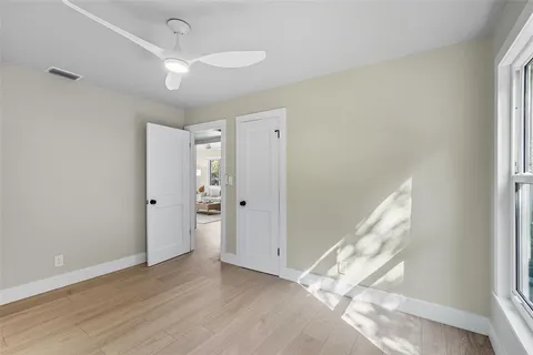 a view of a big room with wooden floor and windows