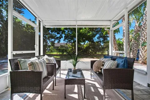 a living room with furniture and floor to ceiling windows