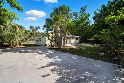 a view of a house with backyard and trees