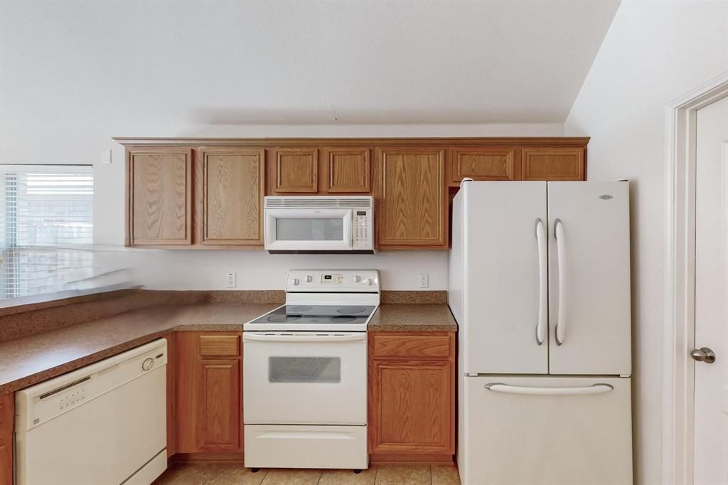 7544 Fresh Springs Road Fort Worth, TX 76120 - Photo 6 of 16 a kitchen with a refrigerator sink stove and cabinets