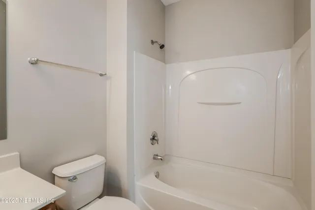 a white toilet sitting next to a bath tub