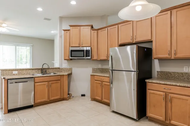 a kitchen with stainless steel appliances granite countertop a refrigerator sink and stove