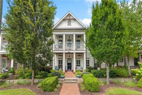 a front view of a house with yard and green space