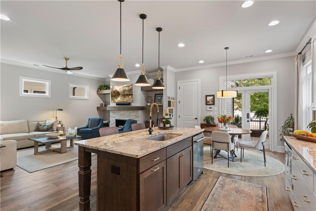 126 Academy Street Alpharetta, GA 30009 - Photo 21 of 74 a room with stainless steel appliances kitchen island granite countertop a sink a stove and a wooden floors