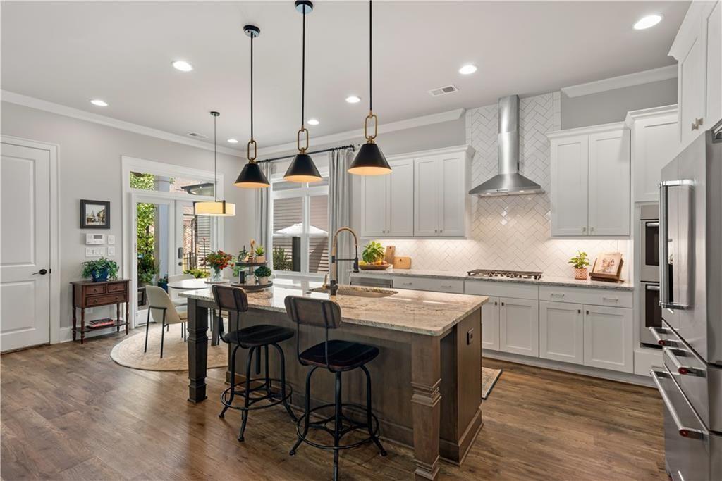 126 Academy Street Alpharetta, GA 30009 - Photo 22 of 74 a kitchen with stainless steel appliances granite countertop a stove a sink a refrigerator a center island and a wooden floor