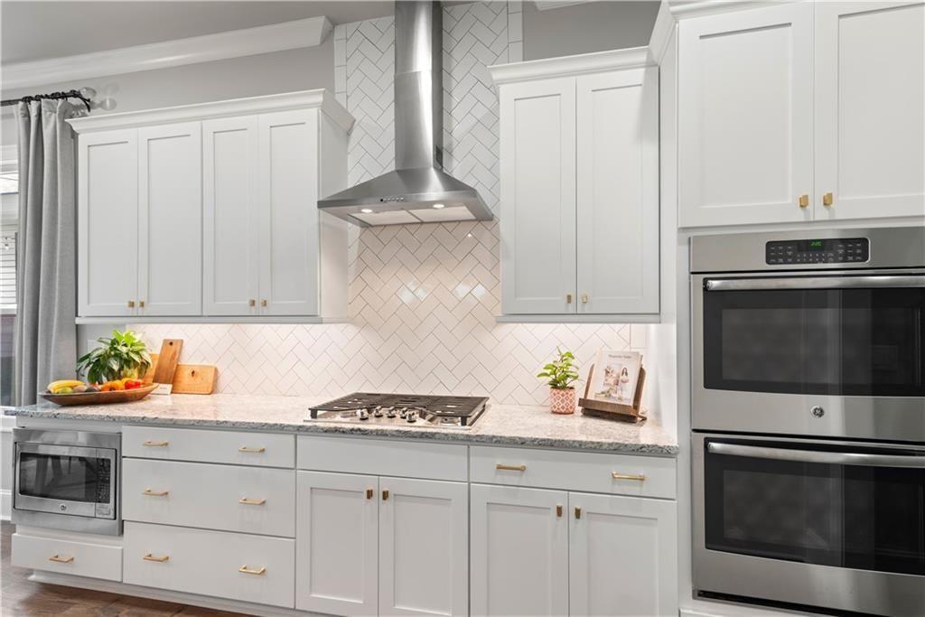 126 Academy Street Alpharetta, GA 30009 - Photo 25 of 74 a kitchen with stainless steel appliances granite countertop white cabinets and a stove