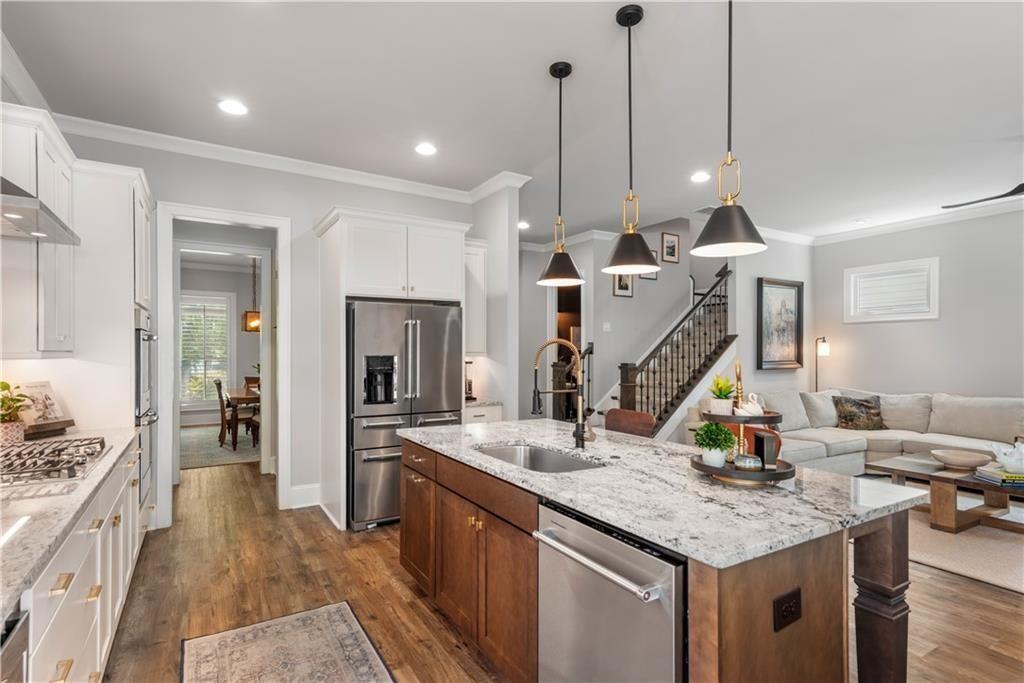 126 Academy Street Alpharetta, GA 30009 - Photo 26 of 74 a kitchen with stainless steel appliances granite countertop a sink a stove and a wooden floors