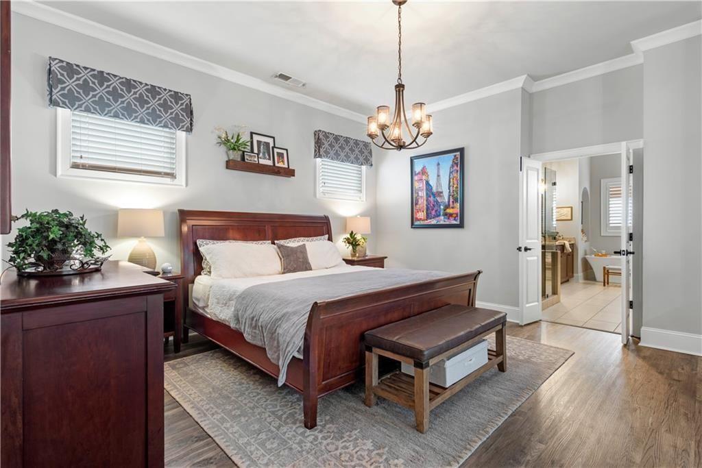 126 Academy Street Alpharetta, GA 30009 - Photo 33 of 74 a spacious bedroom with a bed and a chandelier