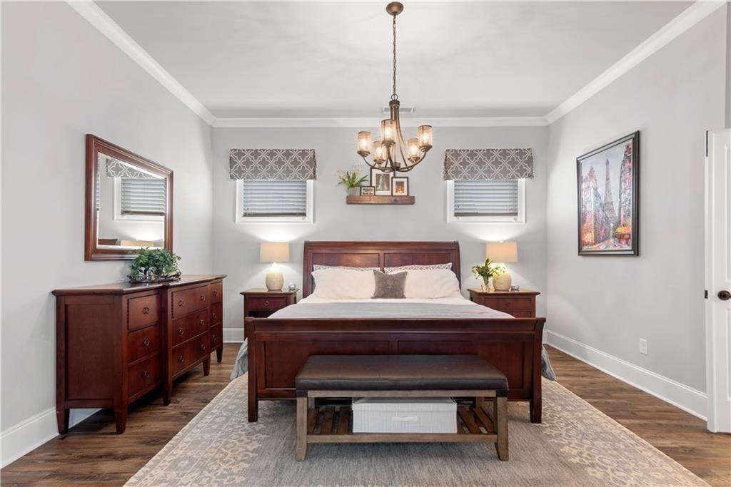 126 Academy Street Alpharetta, GA 30009 - Photo 34 of 74 a bedroom with a bed and paintings on the wall