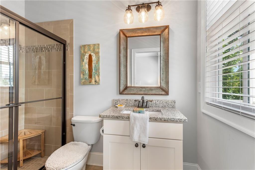 126 Academy Street Alpharetta, GA 30009 - Photo 45 of 74 a bathroom with a toilet sink vanity and mirror