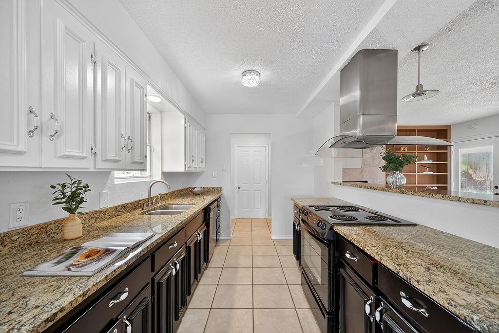 9662 Ferndale Road Dallas, TX 75238 - Photo 14 of 39 a kitchen with stainless steel appliances granite countertop a stove a sink and a refrigerator