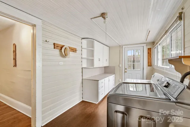 a view of kitchen and empty room with wooden floor