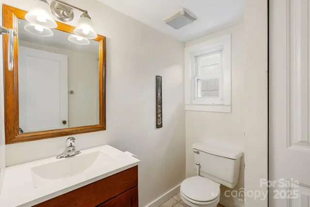 a bathroom with a sink vanity mirror and toilet