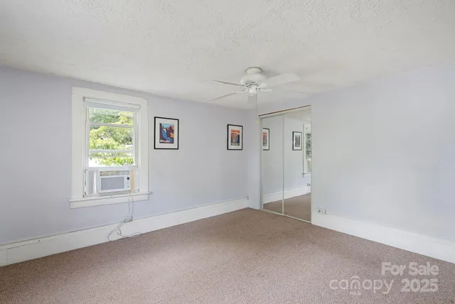 an empty room with windows and closet