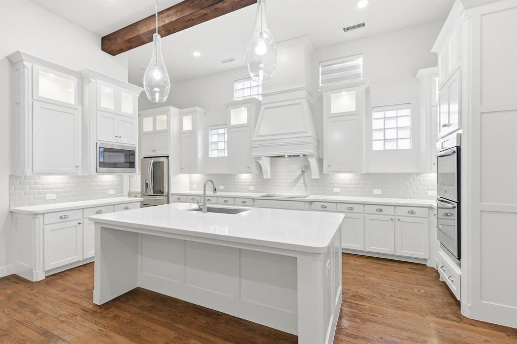 3968 Sevilla Drive Frisco, TX 75034 - Photo 17 of 38 a kitchen with granite countertop white cabinets and white appliances