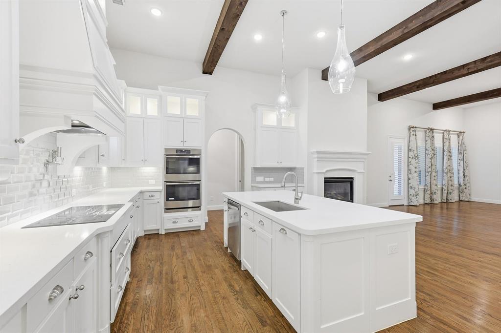 3968 Sevilla Drive Frisco, TX 75034 - Photo 18 of 38 a large kitchen with stainless steel appliances kitchen island granite countertop a sink and cabinets