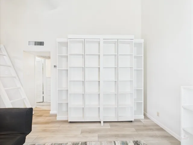 a view of a livingroom with wooden floor and staircase