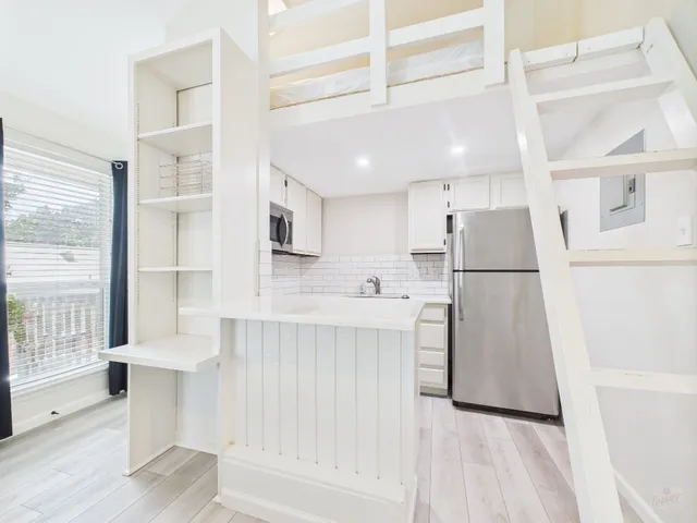 a kitchen with white cabinets and refrigerator