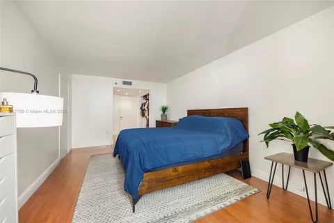 a bedroom with a bed and a potted plant