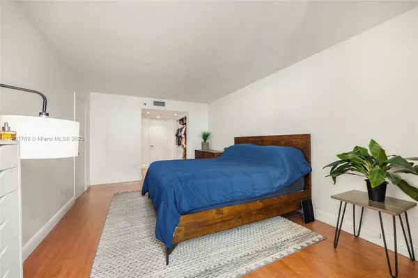 a bedroom with a bed and a potted plant