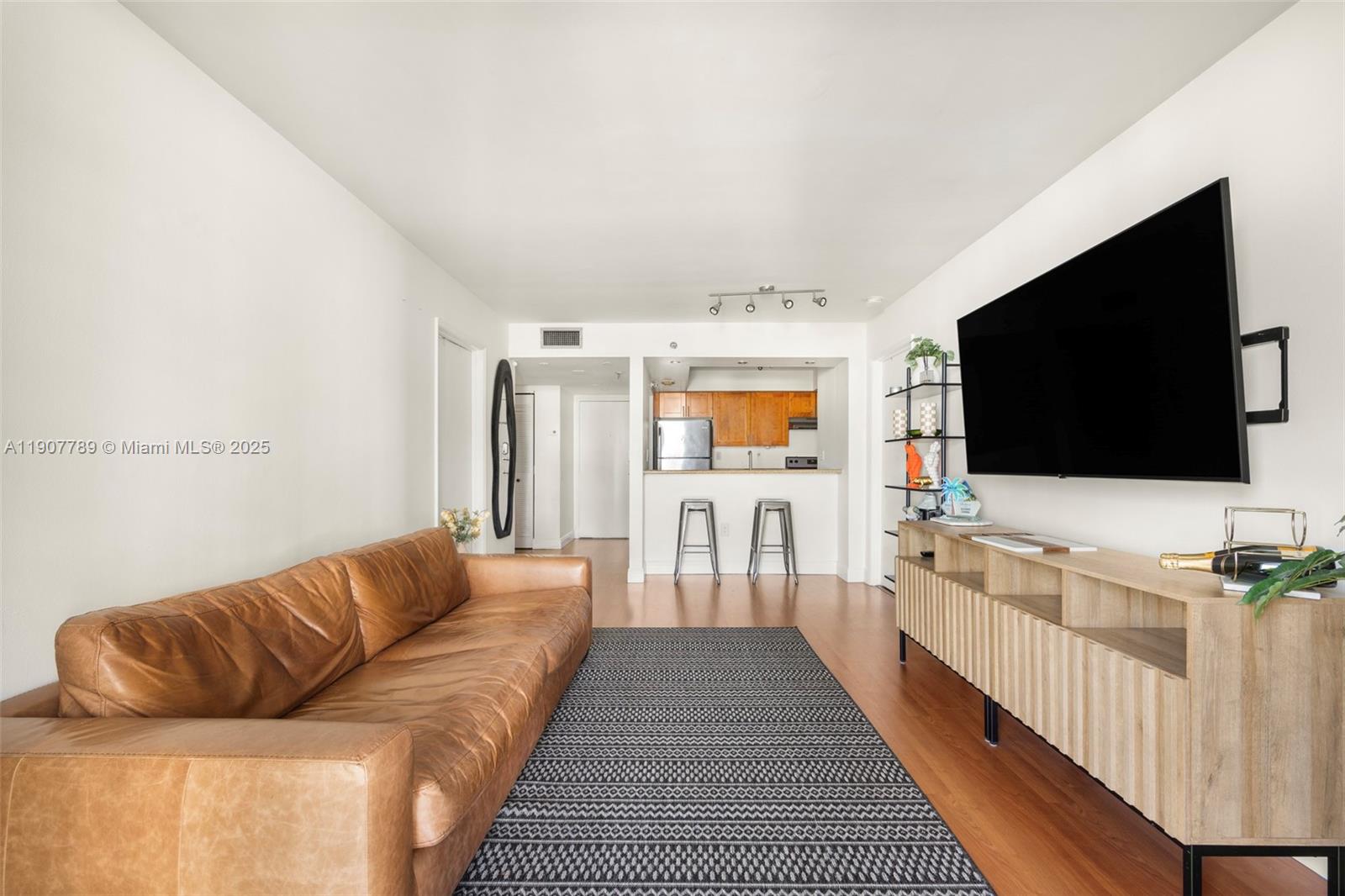 850 North Miami Avenue, Unit W906 Miami, FL 33136 - Photo 2 of 23 a living room with furniture and a flat screen tv