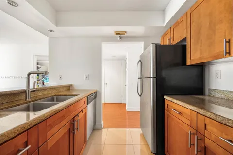 a kitchen with stainless steel appliances granite countertop a refrigerator and a sink