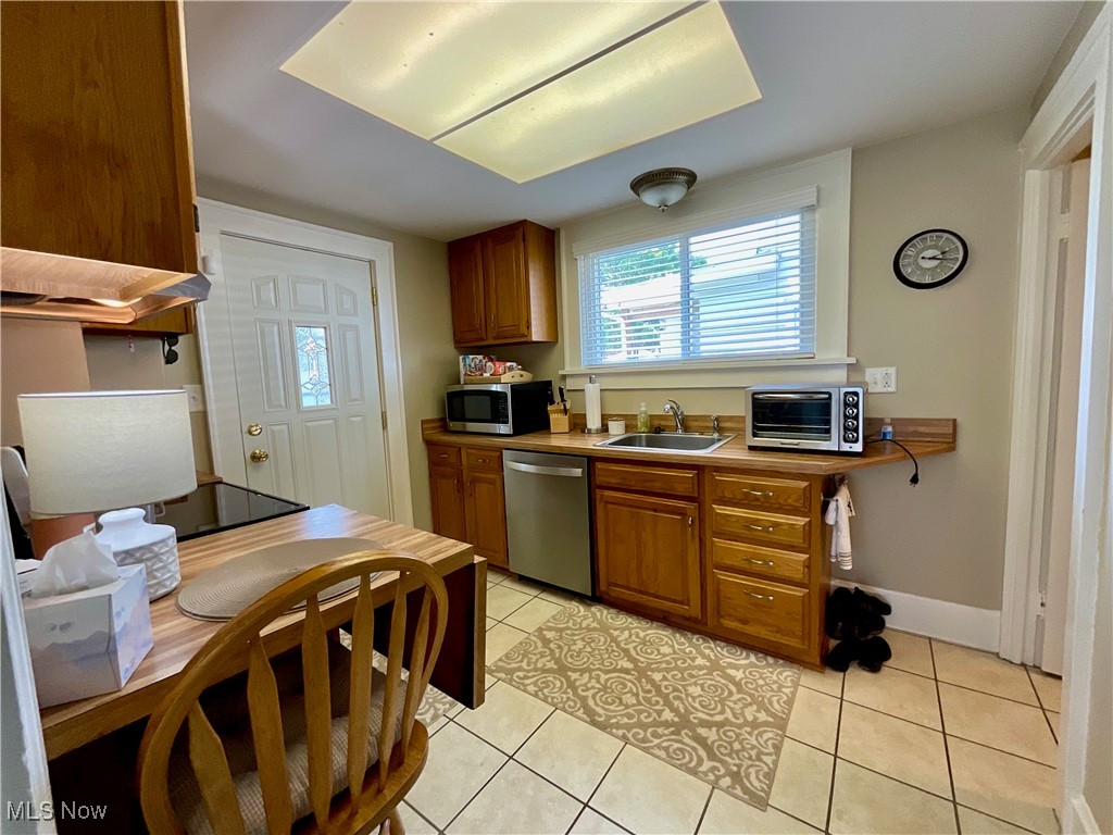 904 Chalker Street Akron, OH 44310 - Photo 18 of 28 Kitchen with appliances with stainless steel finishes, brown cabinetry, light tile patterned floors, and light countertops