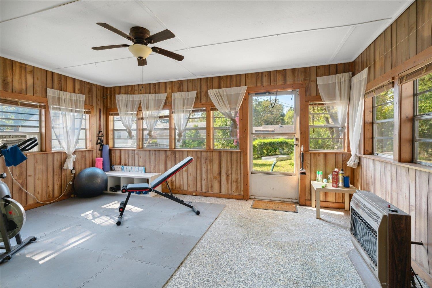977 Waring Road Memphis, TN 38122 - Photo 20 of 32 Workout room featuring ceiling fan, heating unit, and wooden walls