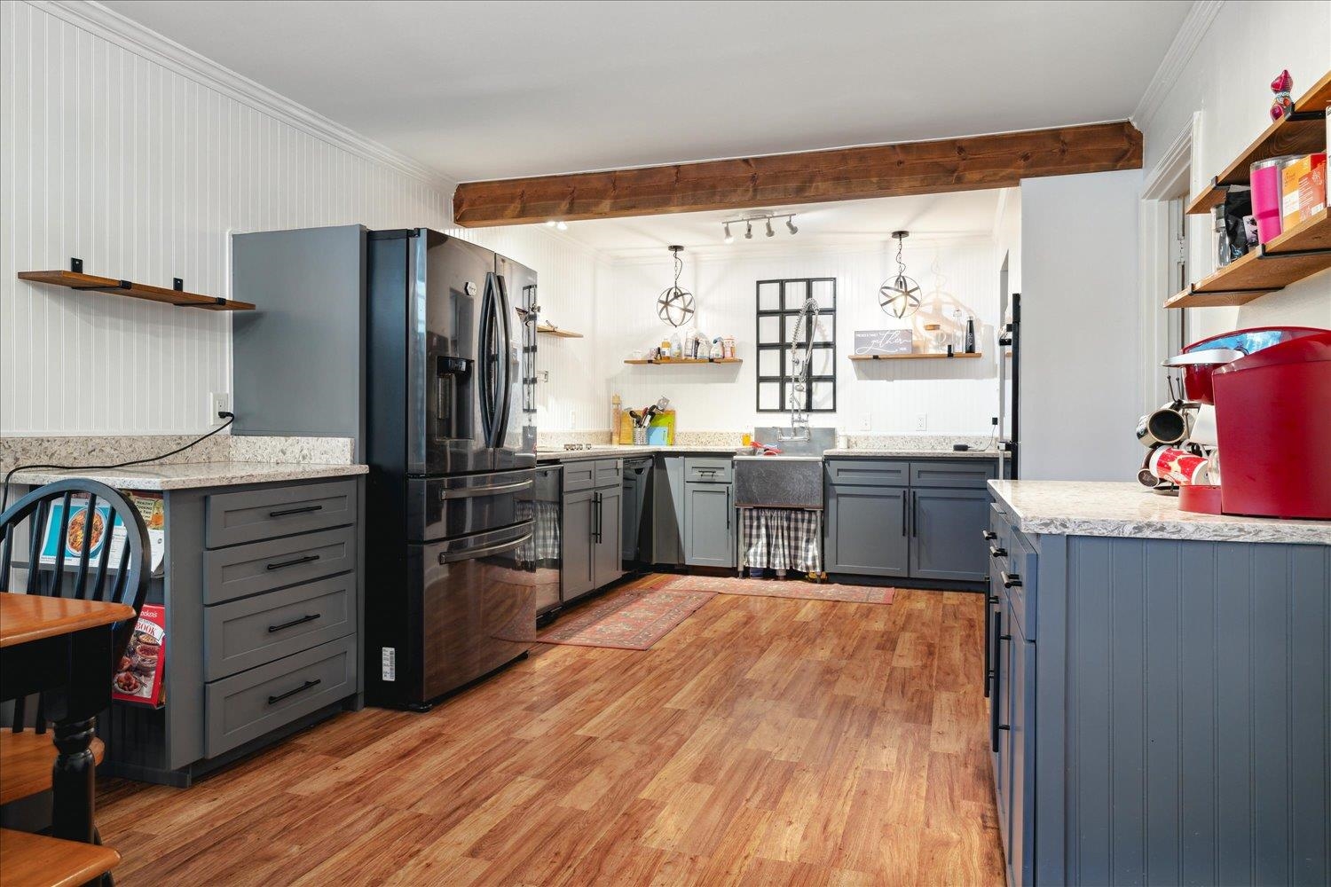 977 Waring Road Memphis, TN 38122 - Photo 7 of 32 Kitchen with hanging light fixtures, light hardwood / wood-style flooring, ornamental molding, gray cabinetry, and stainless steel refrigerator with ice dispenser