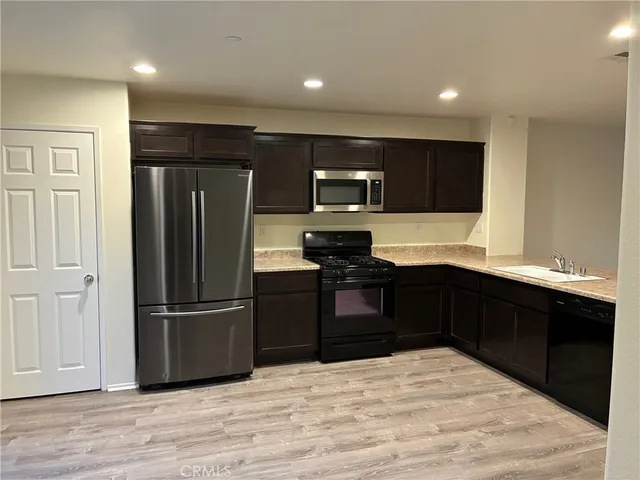 a kitchen with kitchen island granite countertop stainless steel appliances and refrigerator