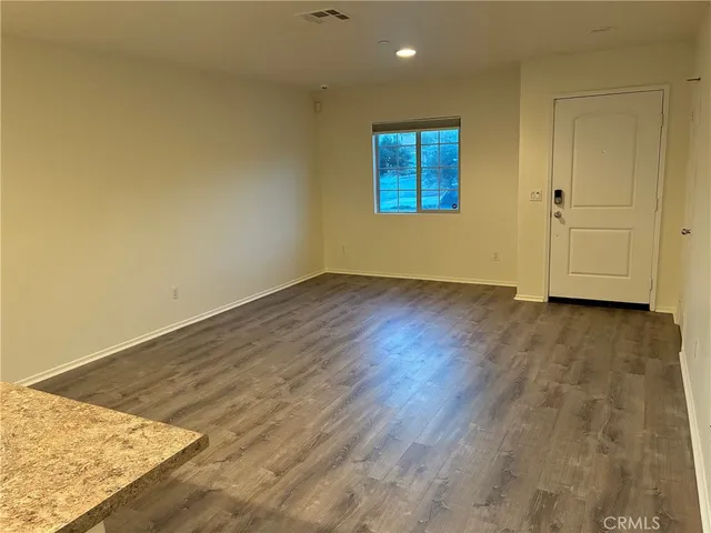 an empty room with wooden floor and cabinet