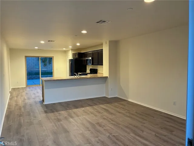 a view of kitchen with kitchen island wooden floor and center island