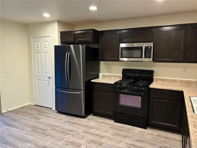 a kitchen with stainless steel appliances granite countertop a refrigerator and a stove top oven