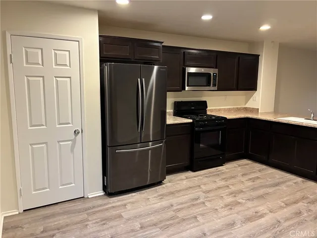 a kitchen with stainless steel appliances granite countertop a refrigerator and a sink