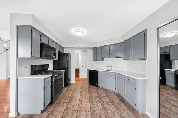 a kitchen with stainless steel appliances granite countertop a stove top oven a sink dishwasher and a refrigerator with wooden floor