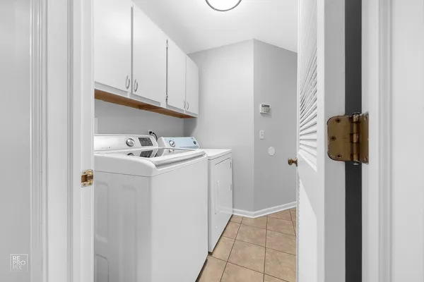 a utility room with cabinets washer and dryer