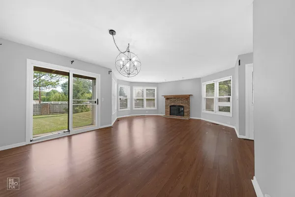 a view of empty room with wooden floor and fireplace