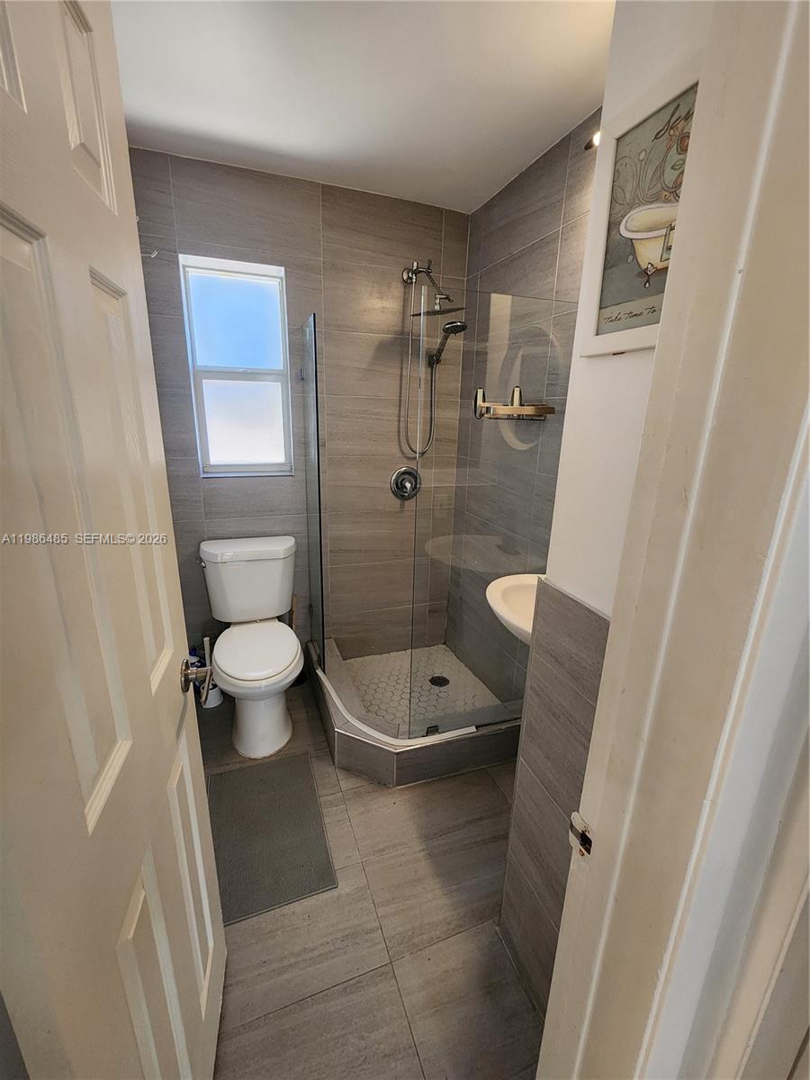 315 Walnut Street, Unit 2 Hollywood, FL 33019 - Photo 14 of 23 a bathroom with a granite countertop sink toilet and shower