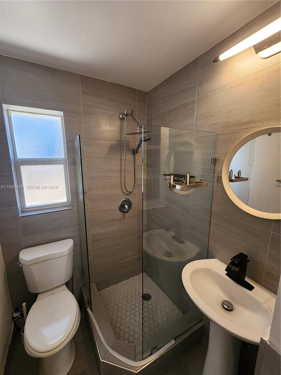 315 Walnut Street, Unit 2 Hollywood, FL 33019 - Photo 16 of 23 a bathroom with a sink toilet and shower