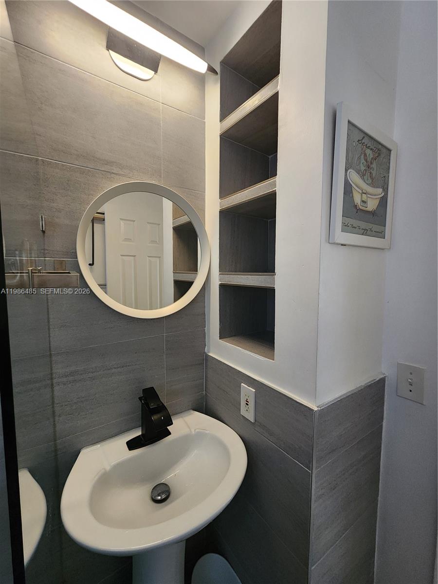 315 Walnut Street, Unit 2 Hollywood, FL 33019 - Photo 18 of 23 a bathroom with a sink and a mirror