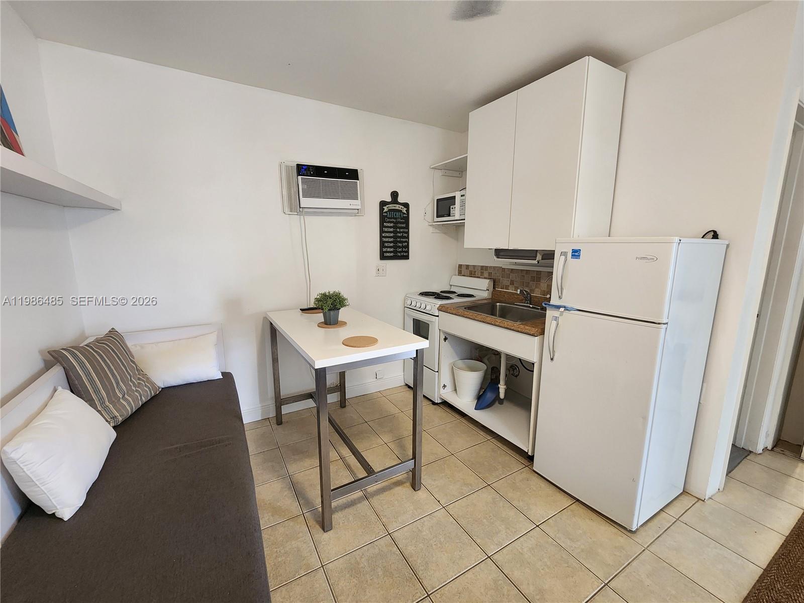 315 Walnut Street, Unit 2 Hollywood, FL 33019 - Photo 9 of 23 a kitchen with stainless steel appliances kitchen island granite countertop a refrigerator and a stove top oven