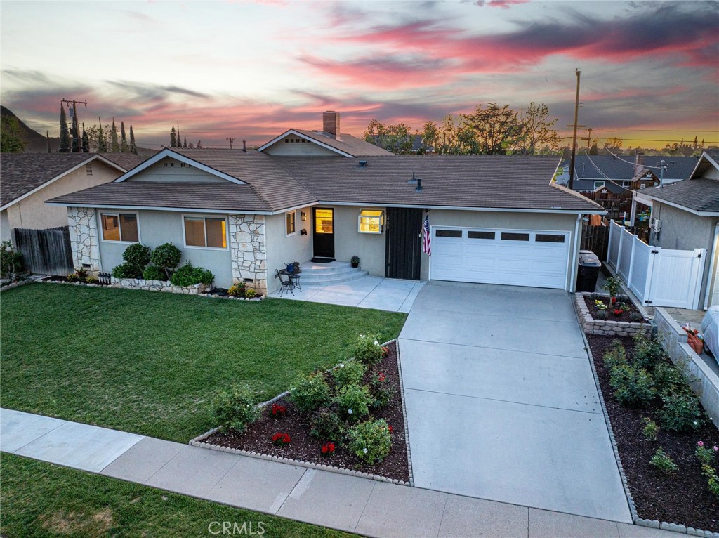 a front view of a house with a garden and yard
